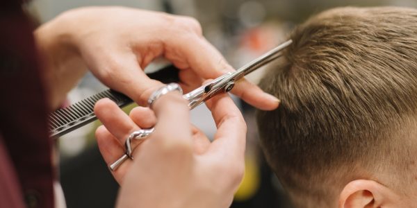 vista-del-primo-piano-dell-uomo-che-ottiene-un-taglio-di-capelli_23-2148506231